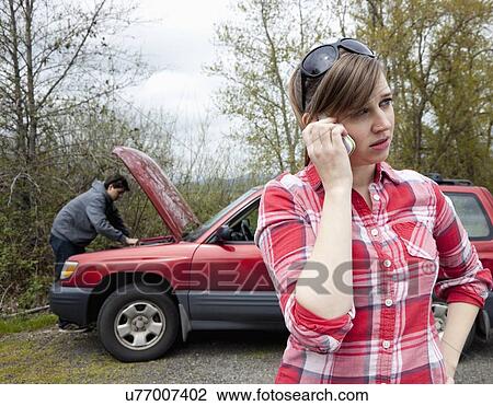 Stock Image - USA, Oregon, Ashland, young couple having car breakdown. Fotosearch