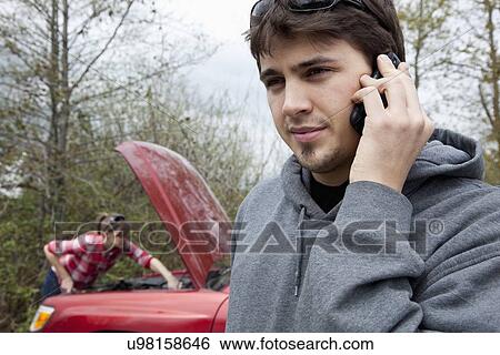 Stock Photograph - USA, Oregon, Ashland, young couple having car breakdown. Fotosearch