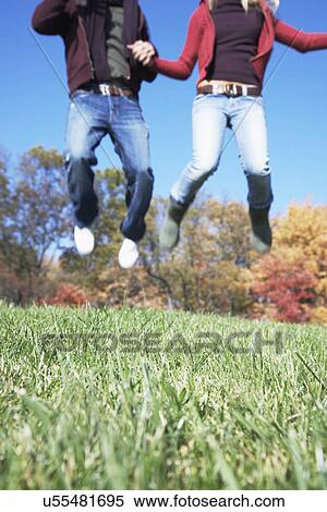 USA, Pennsylvania, Doylestown, low section of teenage couple (16-17) holding hands and jumping in park View Large Photo Image Stock Photography - USA, Pennsylvania, Doylestown, low section of teenage couple (16-17) holding hands and jumping in park. Fotosearch
