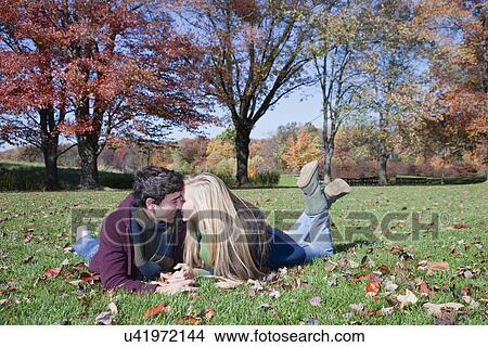 USA, Pennsylvania, Doylestown, teenage couple (16-17) lying on lawn in park, flirting View Large Photo Image Picture - USA, Pennsylvania, Doylestown, teenage couple (16-17) lying on lawn in park, flirting. Fotosearch