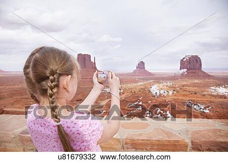 Stock Image - USA, Utah, girl (10-11) photographing rocky desert. Fotosearch