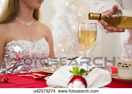 Waiter pouring wine into glass, girl (12-13) in background View Large Photo Image Picture - Waiter pouring wine into glass, girl (12-13) in background. Fotosearch