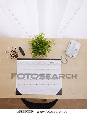Picture - Wall calendar on desk. Fotosearch