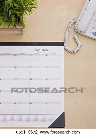Stock Image - Wall calendar on desk. Fotosearch