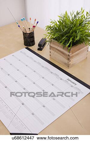 Stock Photo - Wall calendar on desk. Fotosearch