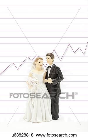Wedding figurines in front of financial chart, studio shot View Large Photo Image Stock Photo - Wedding figurines in front of financial chart, studio shot. Fotosearch
