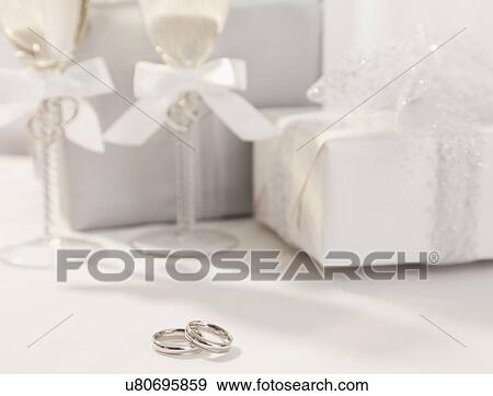 Wedding rings, champagne flutes and wedding presents View Large Photo Image Stock Photo - Wedding rings, champagne flutes and wedding presents. Fotosearch