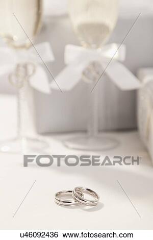 Stock Photograph - Wedding rings, champagne flutes and wedding presents. Fotosearch