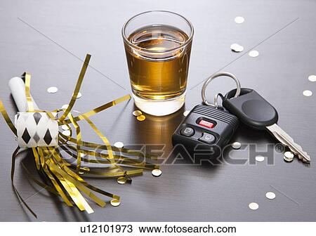 Stock Image - Whiskey party horn and car keys. Fotosearch