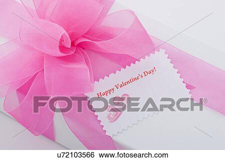 Stock Photograph - White box with pink ribbon and Valentine's Day greeting card. Fotosearch
