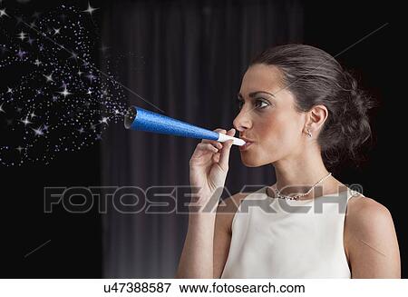 Woman blowing stars out of paper blow horn View Large Photo Image Stock Photo - Woman blowing stars out of paper blow horn. Fotosearch