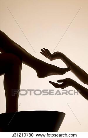 Stock Image - Woman having foot bath in spa, low section. Fotosearch