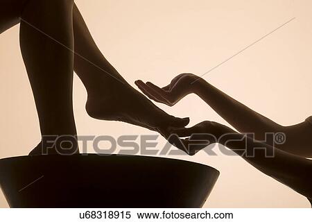 Stock Photography - Woman having foot bath in spa, low section. Fotosearch