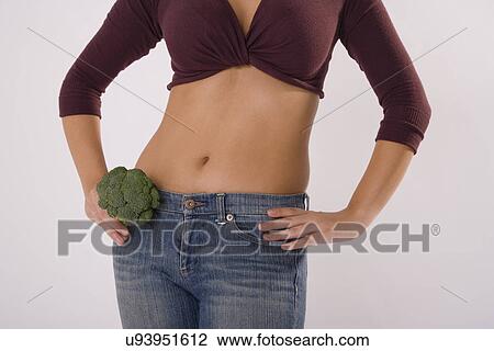 Stock Image - Woman holding broccoli by waist. Fotosearch