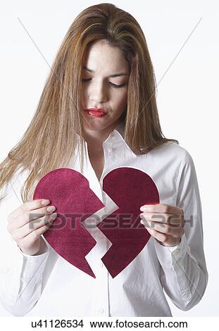 Picture - Woman holding broken heart. Fotosearch