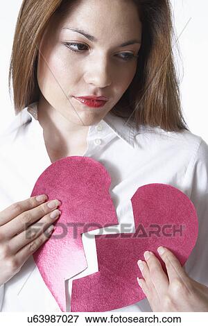 Stock Photo - Woman holding broken heart. Fotosearch
