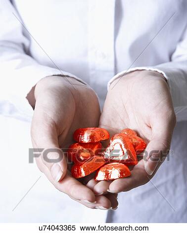 Woman holding heart shape candy View Large Photo Image Stock Photography - Woman holding heart shape candy. Fotosearch