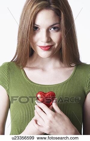 Stock Photo - Woman holding heart shape Valentine's gift, portrait. Fotosearch