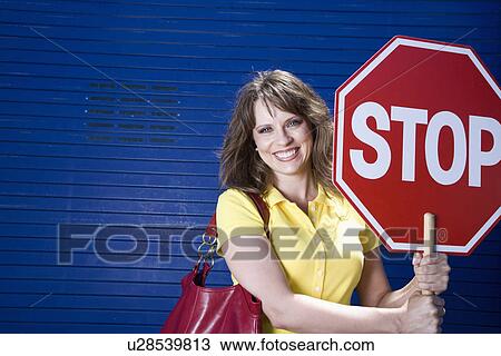 Woman holding stop sign, portrait View Large Photo Image Stock Image - Woman holding stop sign, portrait. Fotosearch