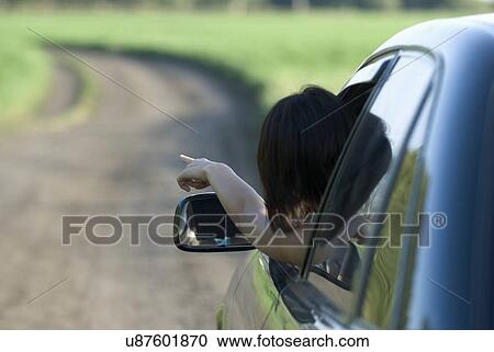 Woman leaning outside from car window and pointing View Large Photo Image Stock Image - Woman leaning outside from car window and pointing. Fotosearch