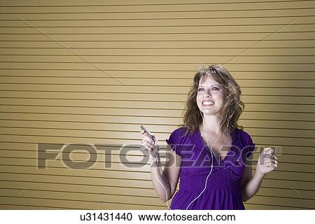 Woman listening to music outdoors View Large Photo Image Stock Image - Woman listening to music outdoors. Fotosearch