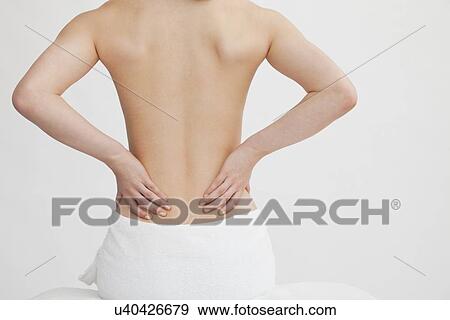Stock Photo - Woman with hands on back. Fotosearch