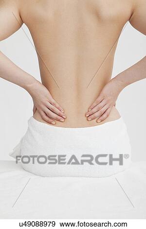 Stock Photo - Woman with hands on back. Fotosearch