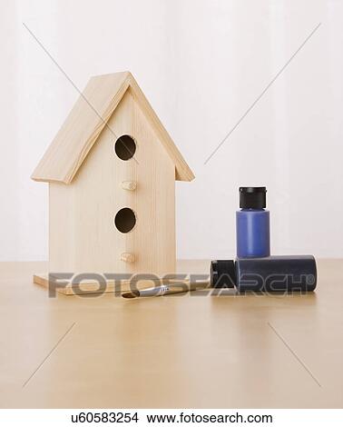 Picture - Wooden birdhouse with paints and paintbrush. Fotosearch