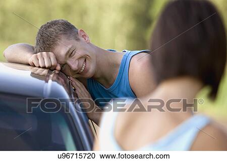 Stock Image - Young couple by car. Fotosearch