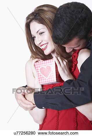 Young couple embracing on Valentine's day, woman holding gift View Large Photo Image Stock Image - Young couple embracing on Valentine's day, woman holding gift. Fotosearch