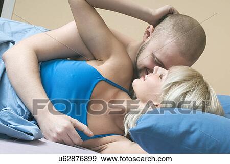 Stock Photo - Young couple flirting in bed. Fotosearch