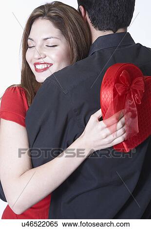 Young couple hugging on Valentine's day, woman holding gift View Large Photo Image Stock Photography - Young couple hugging on Valentine's day, woman holding gift. Fotosearch