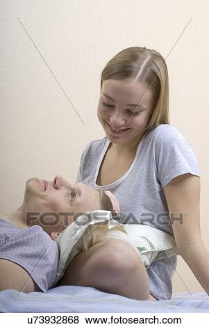 Young couple relaxing on bed View Large Photo Image Stock Photo - Young couple relaxing on bed. Fotosearch