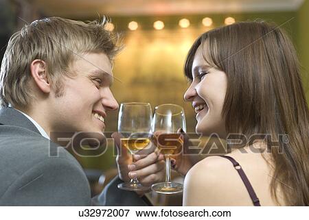 Stock Photo - Young couple toasting with white wine. Fotosearch
