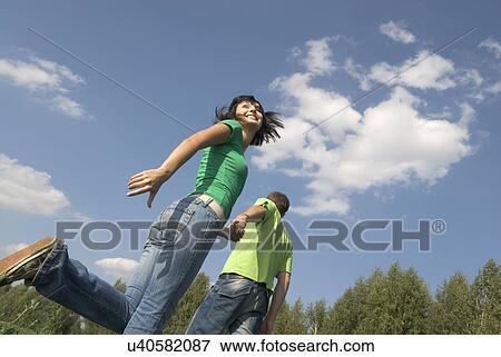 Young couple walking trough field View Large Photo Image Stock Photo - Young couple walking trough field. Fotosearch