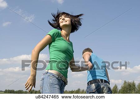 Stock Photography - Young couple walking trough field. Fotosearch