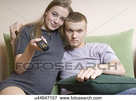 Young couple watching television View Large Photo Image Stock Photo - Young couple watching television. Fotosearch