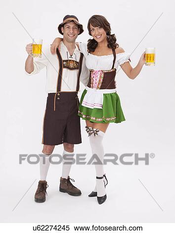 Young couple wearing Oktoberfest costume holding beer stein, studio shot View Large Photo Image Stock Photography - Young couple wearing Oktoberfest costume holding beer stein, studio shot. Fotosearch