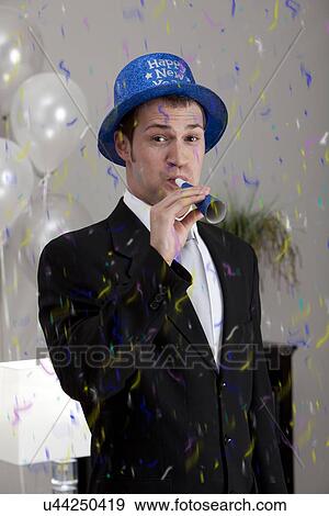 Stock Photo - Young man celebrating birthday, blowing. Fotosearch