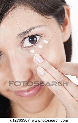 Young woman applying moisturizer under eye View Large Photo Image Stock Photo - Young woman applying moisturizer under eye. Fotosearch