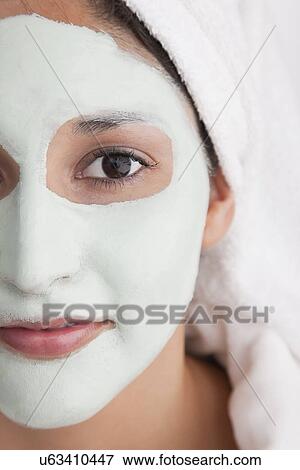 Stock Photo - Young woman having facial mask. Fotosearch