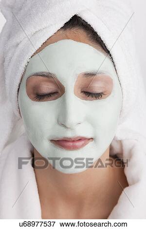 Stock Photo - Young woman having facial mask. Fotosearch