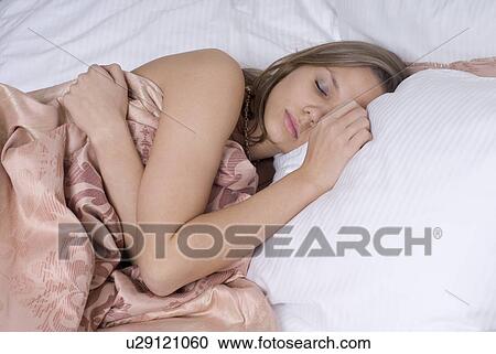 Young woman sleeping in bed View Large Photo Image Stock Image - Young woman sleeping in bed. Fotosearch
