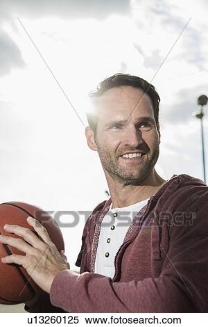 Basketball player holding basketball View Large Photo Image Stock Photography - Basketball player holding basketball. Fotosearch