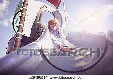 Picture - Boy coming down slide on front. Fotosearch