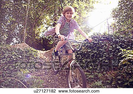 Boy cycling through forest View Large Photo Image Stock Image - Boy cycling through forest. Fotosearch