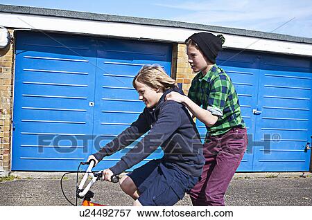 Stock Photo - Boy giving friend a ride on bike. Fotosearch