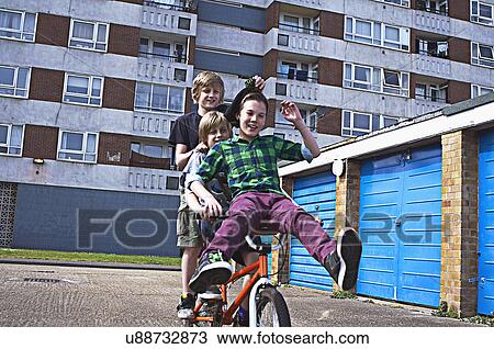 Stock Image - Boy giving friends a ride on bike. Fotosearch