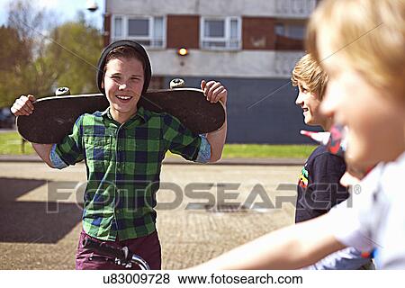 Boy holding skateboard View Large Photo Image Stock Photo - Boy holding skateboard. Fotosearch
