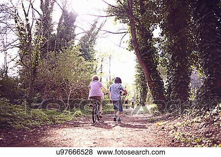Boy on bike with friend on forest path View Large Photo Image Stock Photo - Boy on bike with friend on forest path. Fotosearch